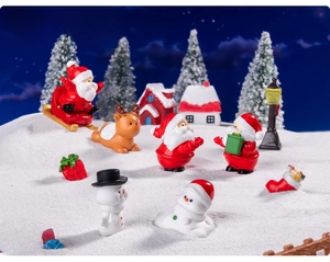 Miniature Christmas landscape scene with Santa, reindeer, and snow house figurines