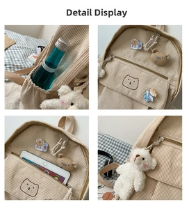 Detalle de mochila de pana beige con bordado de oso y compartimentos organizadores