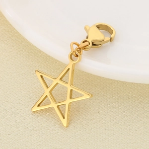 Macro shot of polished gold star pendant with lobster clasp on a beige fabric background