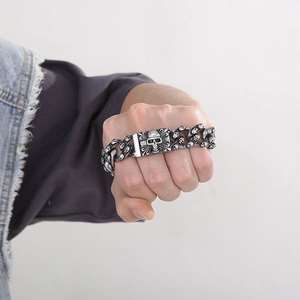 Macro shot of punk skull stainless steel bracelet on fist with detailed bone engravings