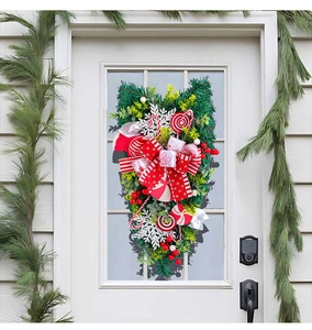 Detail of festive Christmas swag with red bows, pine needles and candy cane ornaments