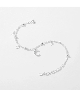 Macro detail of silver-layered bracelet featuring sparkling star and moon charms with beads