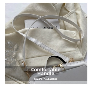 Detail view of white mini suitcase bag with dual zippers and adjustable shoulder strap