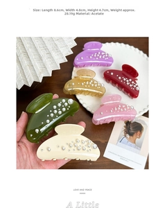 Detail view of pearl acetate hair claws showing 8.6cm size and weight specifications