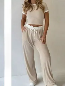 Detail of short sleeve crop top and high waist drawstring wide leg pants in ribbed knit fabric