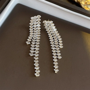 Close-up of silver bow earrings with sparkling crystal tassels in a luxury jewelry box