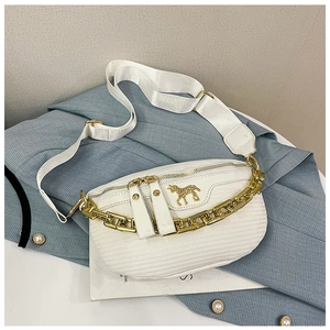 Close-up of white quilted chest bag with gold chunky chain and unicorn emblem detail