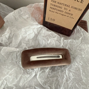 Detail of coffee brown velvet rectangular hair clip with silver hollow metal center