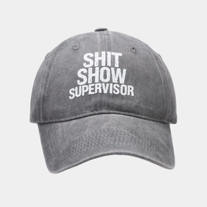 Close-up of washed gray cotton baseball cap featuring Shit Show Supervisor text