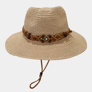Detail of hand-woven straw sun hat featuring decorative wooden beads and turquoise accent