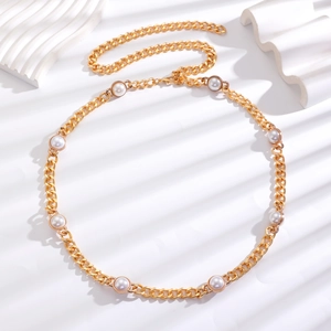 Detail of gold metal waist chain featuring white faux pearls and a lobster clasp