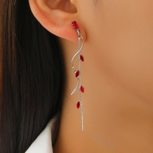 Close-up of red marquise-cut zircon tassel earrings with flowing silver metal chains