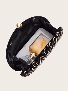 Detail view of the black velvet shell clutch interior with gold bead spiral pattern