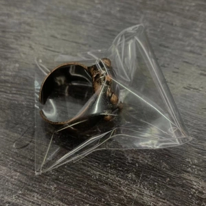 Detail of vintage bronze ring with heart shaped labradorite stone in plastic packaging