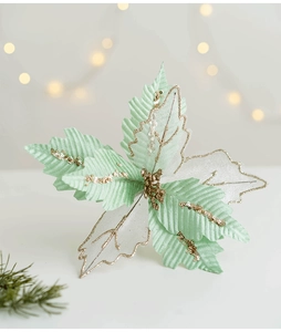 Fiore di poinsettia in tessuto verde menta e argento con glitter oro su sfondo festivo