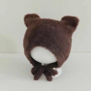 Detail of dark brown faux fur baby hat featuring cute bear ears and long side ties