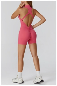 Detail of pink backless yoga romper showing cross-strap design and bodycon fit