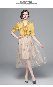 Detail of yellow silk V-neck top and champagne mesh skirt with butterfly embroidery
