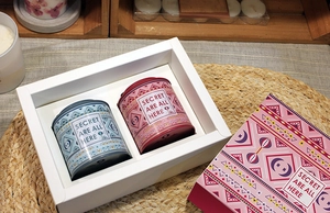 Detail of round tin tea canisters with colorful patterns and gift box packaging