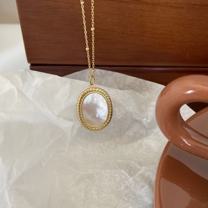 Gold beaded chain necklace with oval white shell pendant and twisted metal edge