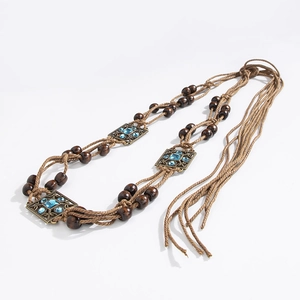 Detail of woven boho waist belt with dark wood beads and blue rhinestone square accents