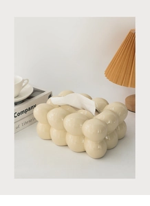 Close-up of cream ceramic cloud tissue box with glossy glaze on a modern coffee table