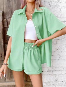 Detail of mint green short sleeve shirt and elastic shorts set with textured fabric