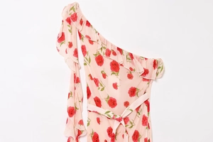Detail of ruffle trim and floral rose print on a light pink one-shoulder dress