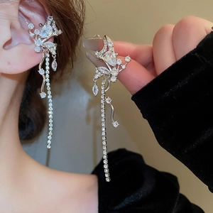 Detail of silver butterfly tassel earrings with sparkling zircon stones on ear