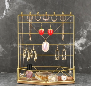 Detail view of gold metal jewelry organizer with hooks on a hexagonal wood base
