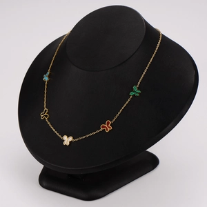 Golden stainless steel necklace with multi-color enamel butterfly charms on a black display