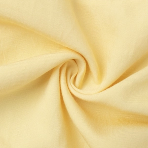 Macro detail of light yellow knitted fabric with soft texture and spiral draping effect