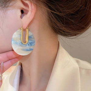 Gros plan de boucles d'oreilles en U plaquées or 18 carats avec créole en acétate marbré