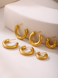 Three pairs of polished gold C-shape hoop earrings in small, medium, and large sizes