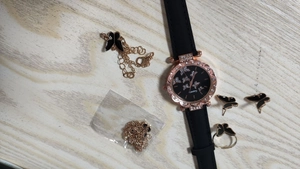 Close-up of butterfly watch set with rhinestone jewelry on a rustic wooden background