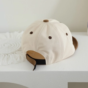 Detail view of cotton baseball cap with adjustable brown strap and color-block design
