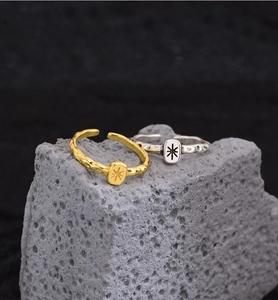 Macro shot of gold and silver starburst lava texture rings on grey volcanic rock