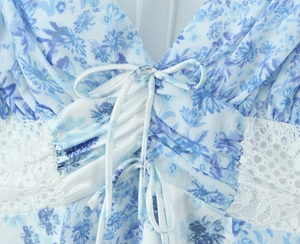 Detailed close-up of the V-neck criss-cross lacing and delicate white lace on floral dress