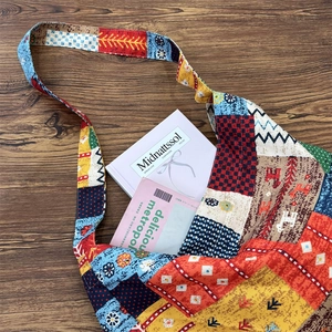 Flat lay of ethnic patchwork canvas bag on wooden table showing large storage capacity