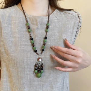 Detailed close-up of ethnic necklace with coconut shell beads and floral fringe pendant