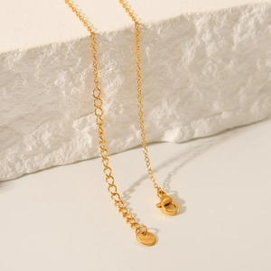 Detailed macro view of 18K gold stainless steel Y-necklace chain with lobster clasp and S.Steel tag