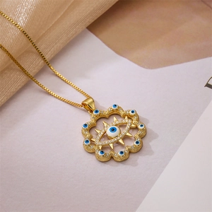 Détail du pendentif œil maléfique doré avec zircons bleus et chaîne élégante