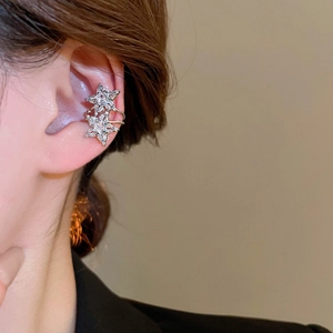 Close-up of double star ear cuff with zircon inlay on a model's ear without piercing