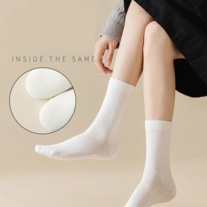 White combed cotton mid-calf socks with seamless toe and ribbed texture shown on feet