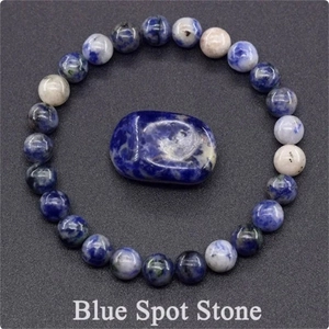 Detailed macro view of natural blue spot stone beads and polished stone on grey surface