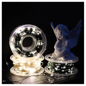 Detail of warm white LED copper wire lights wound on reel with decorative angel statue