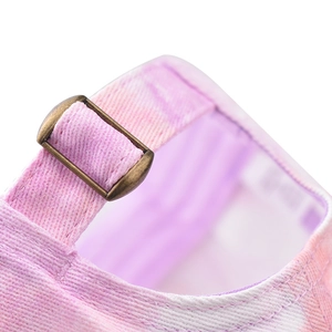 Macro shot of adjustable bronze buckle on pink and purple tie-dye baseball cap