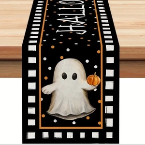 Detail of Halloween ghost and pumpkin pattern linen table runner with checkered border