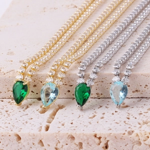 Detailed view of pear-cut green and blue zircon pendants on gold and silver necklaces