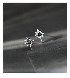Macro shot of S925 silver starburst stud earrings with central black zircon inlay